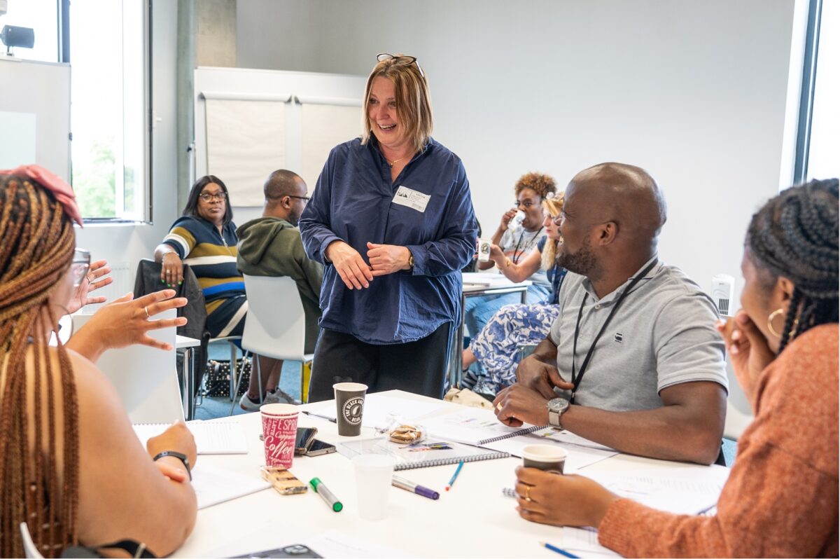 A trainer talking to people around a table in wandsworth professional developmet centre